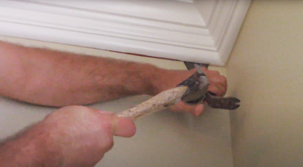 Use a hammer and pry bar to loosen the molding